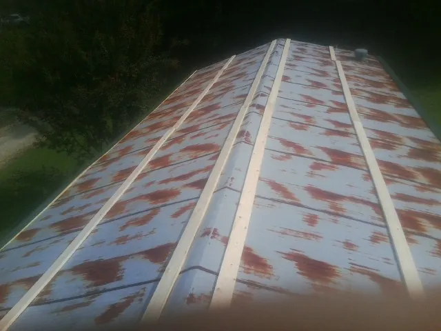 Rusted metal roof panels with new wood purlins before replacement — Storm Damage Roof Repair in Mcadoo by Roofing Brothers