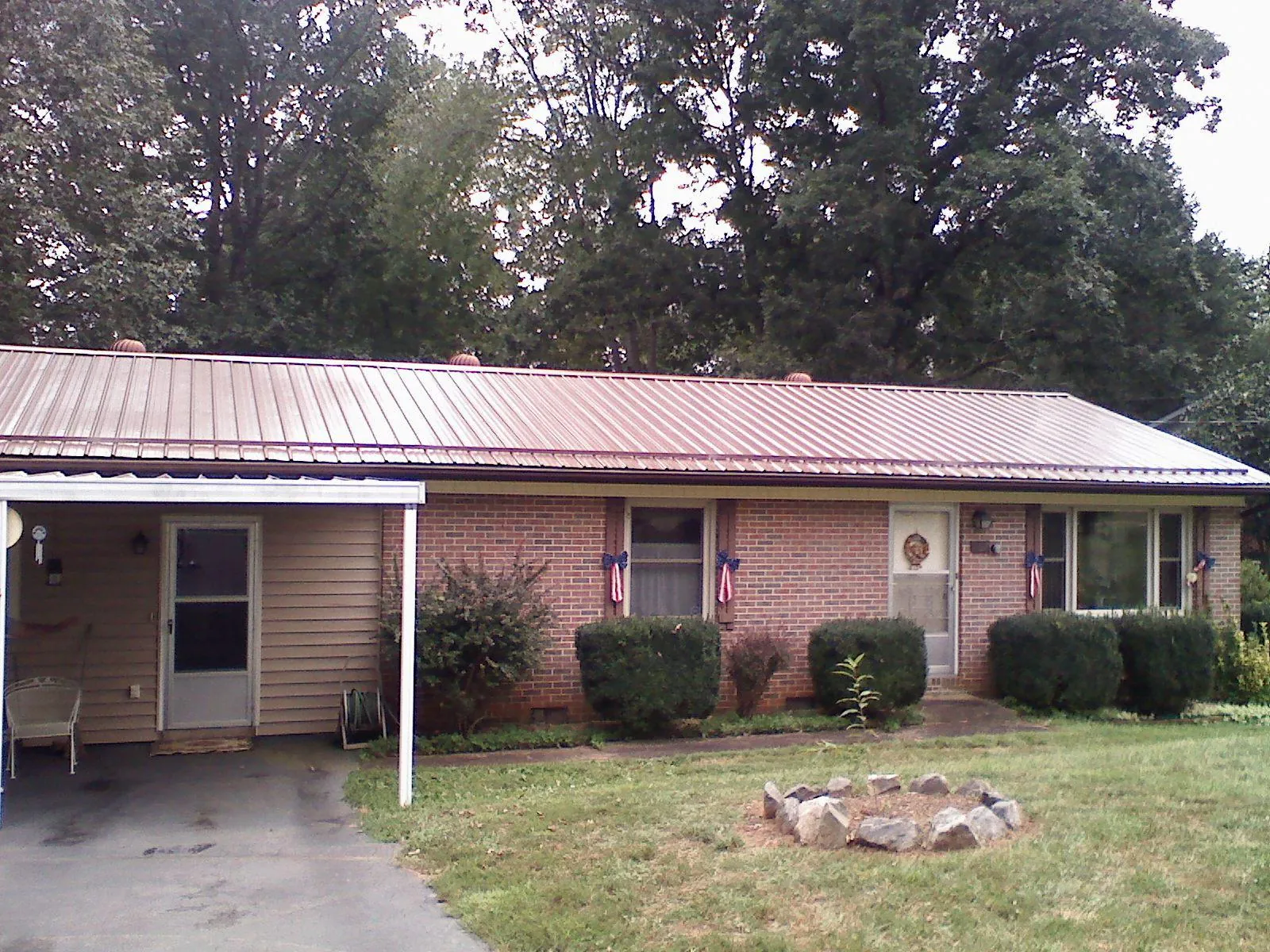 Bronze metal roof and carport on a brick ranch home — Roof Repair work by our crew in Mcadoo